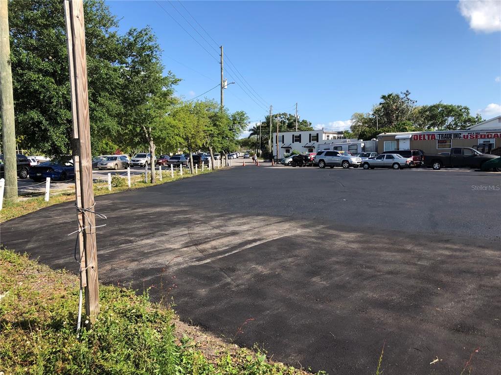 A paved parking lot with several parked cars and a small building in the background — 6180 HAINES ROAD N, ST PETERSBURG, FL