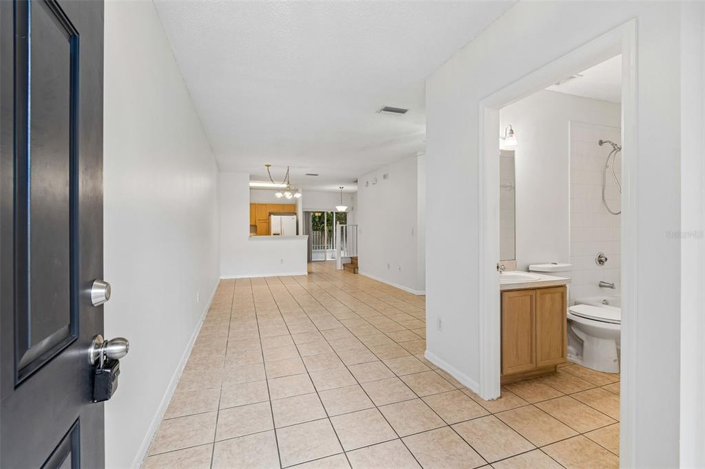 A view from an entryway looking into a tiled living area with an adjacent bathroom — 6245 OSPREY LAKE CIRCLE, RIVERVIEW, FL