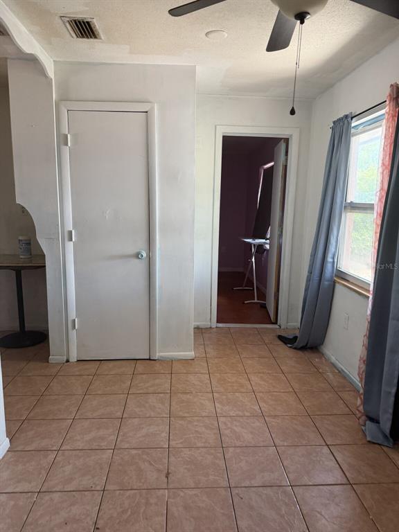 A room with tiled flooring, a white door, a ceiling fan, and a window with curtains — 2509 25TH AVENUE W, BRADENTON, FL