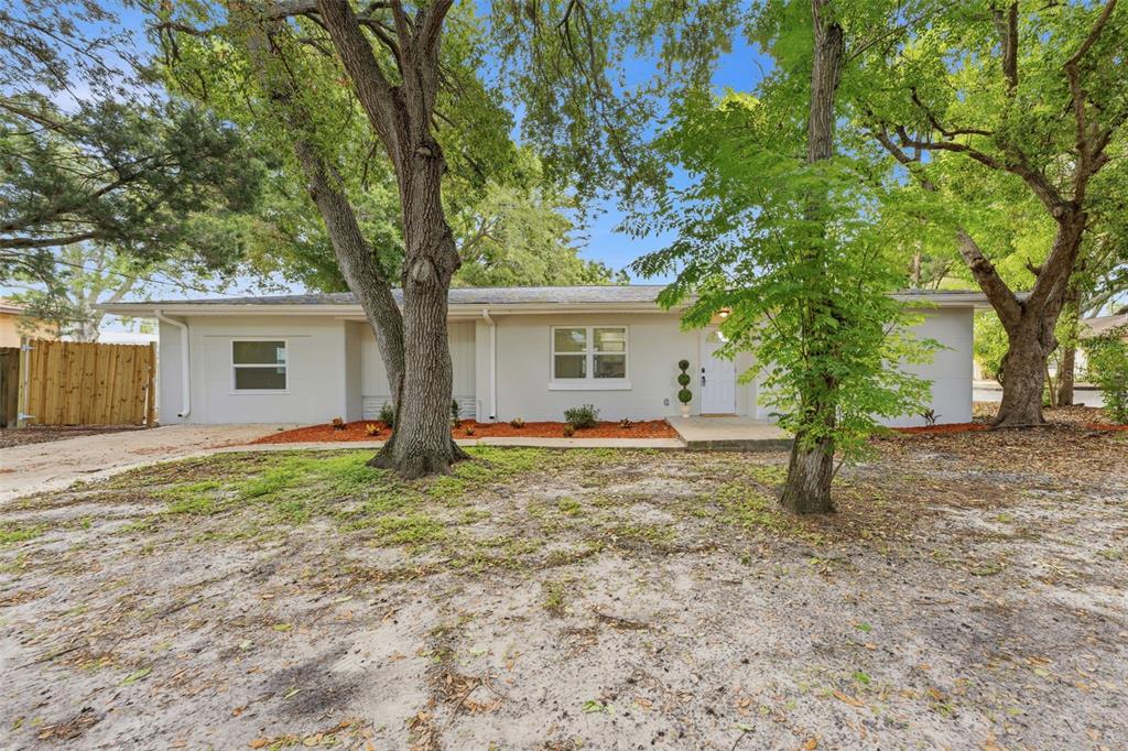 A kitchen features white cabinets, stainless steel appliances, a light-colored backsplash, and wood-look flooring — 264 14TH STREET NW, LARGO, FL