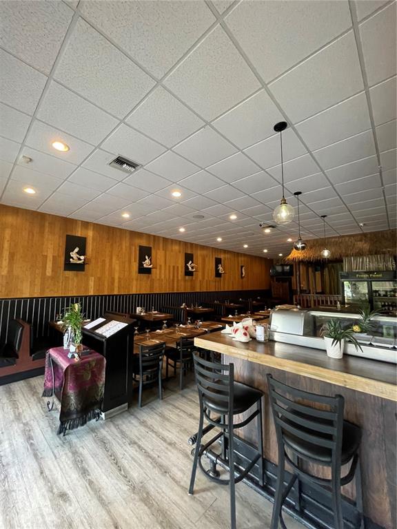 A restaurant interior features a wooden bar, dining tables, and a drop ceiling — 5907 ROOSEVELT BOULEVARD, JACKSONVILLE, FL