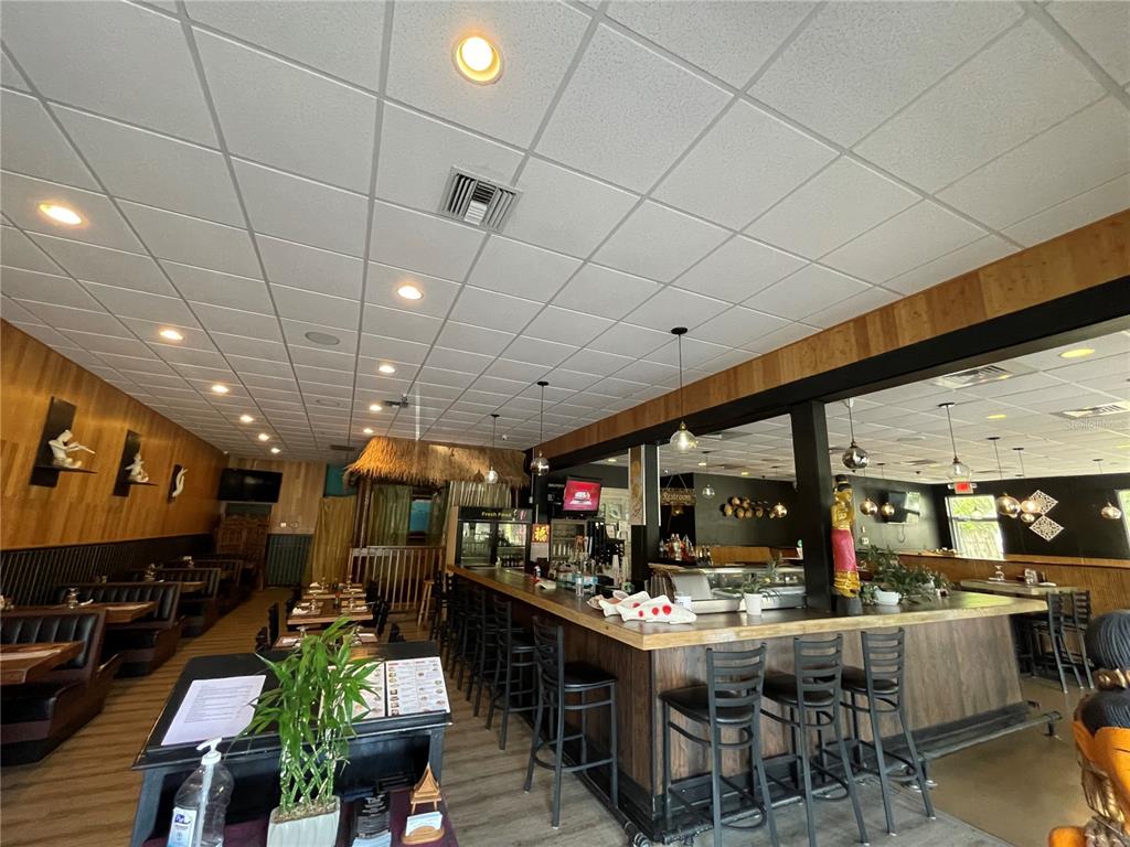 A restaurant interior features a wooden bar, booth seating, and a drop ceiling — 5907 ROOSEVELT BOULEVARD, JACKSONVILLE, FL