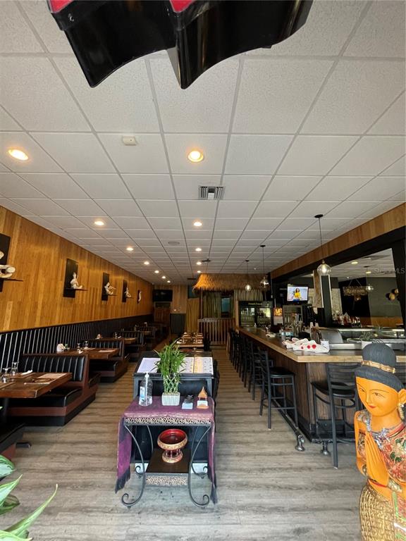 A restaurant interior features wooden wall paneling, a long bar, and booth seating — 5907 ROOSEVELT BOULEVARD, JACKSONVILLE, FL