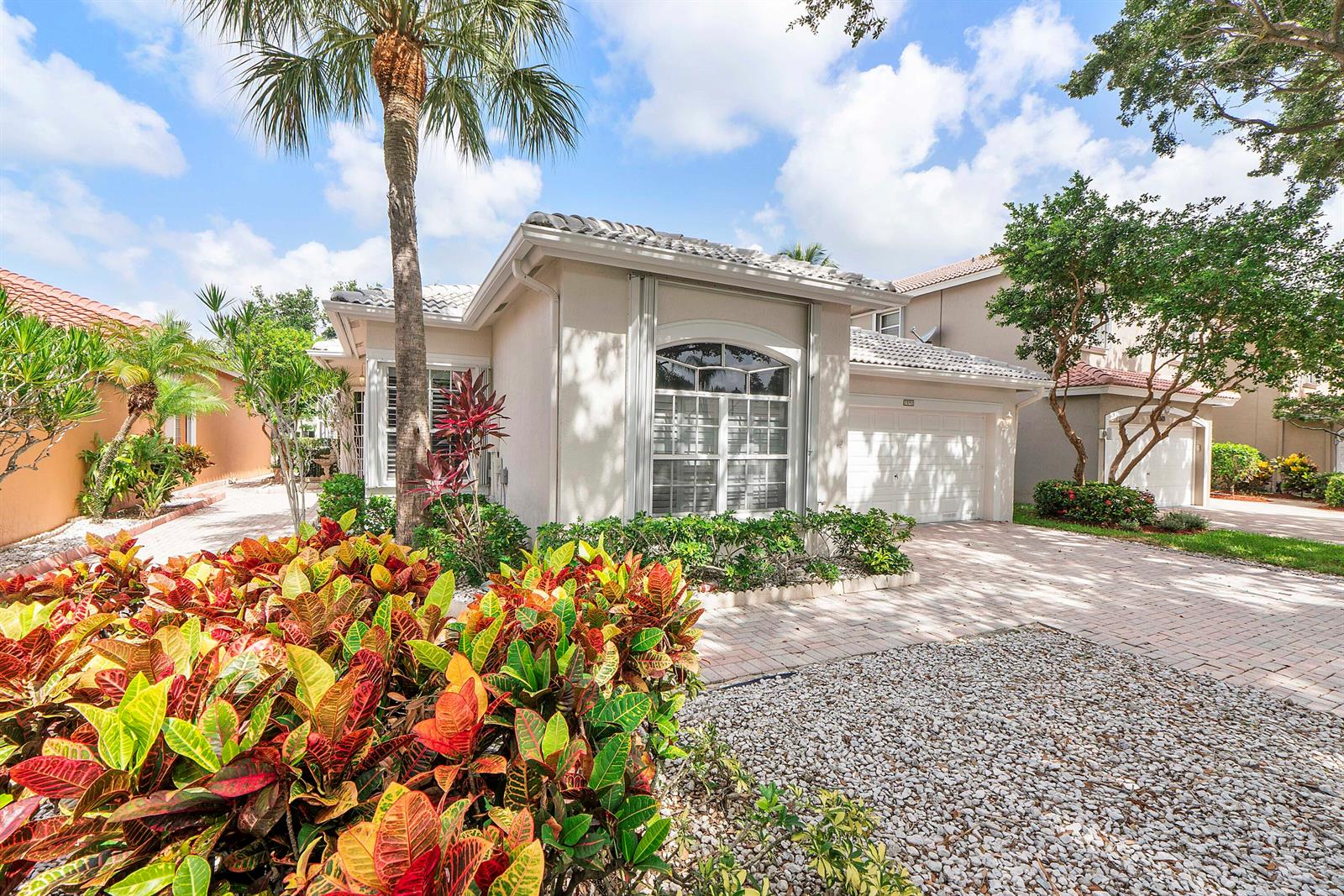 A single-story house with a beige exterior, a tiled roof, and a paved driveway — 7591 NW 59th Way, Parkland FL 33067, PARKLAND, FL