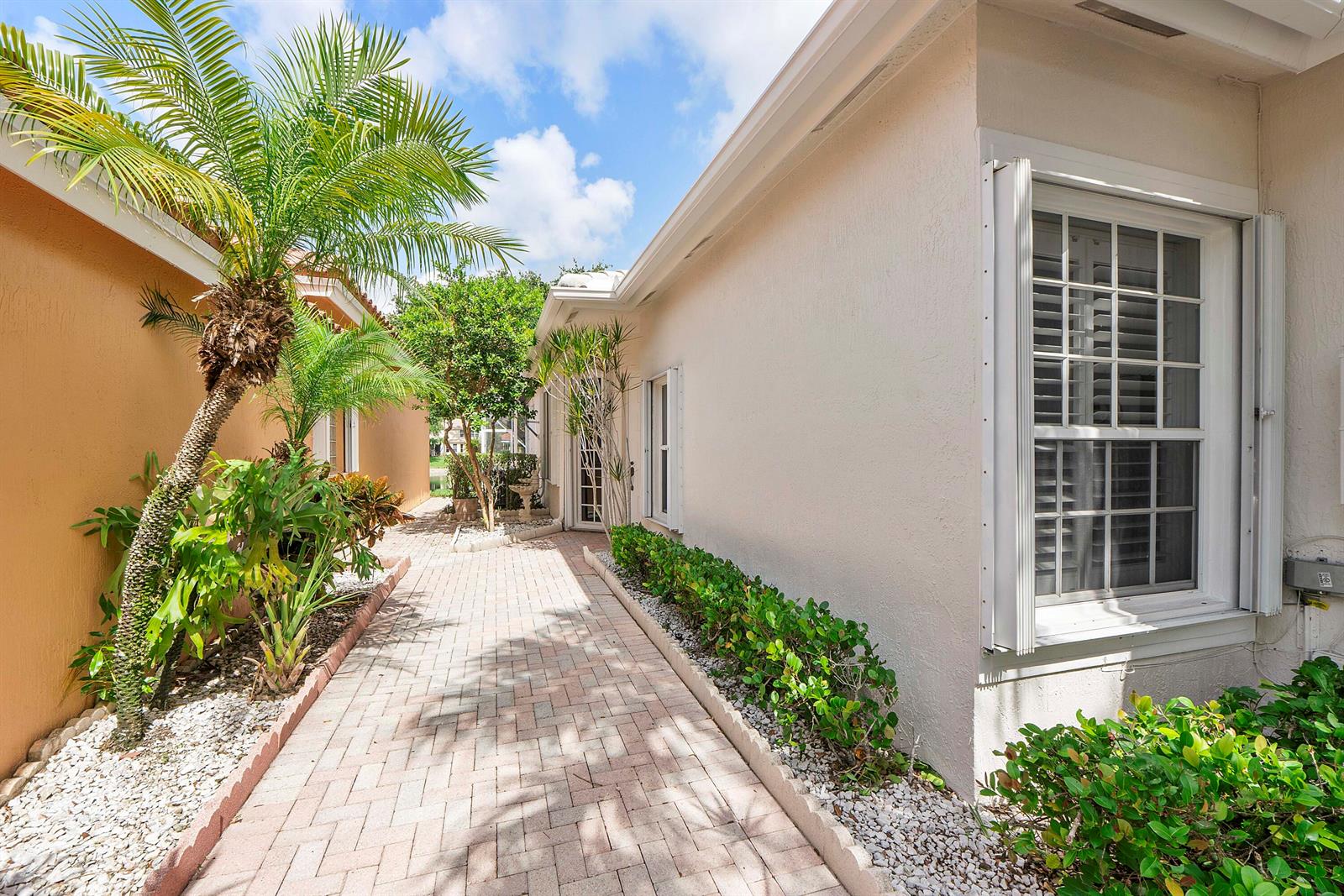 A paved walkway leads between two stucco houses with a palm tree and landscaping — 7591 NW 59th Way, Parkland FL 33067, PARKLAND, FL