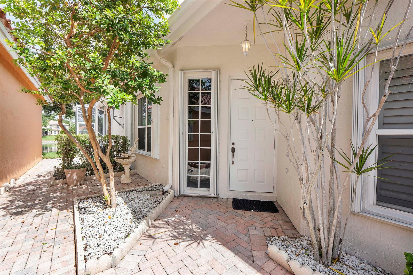 A paved entryway leads to a white front door with a glass storm door — 7591 NW 59th Way, Parkland FL 33067, PARKLAND, FL