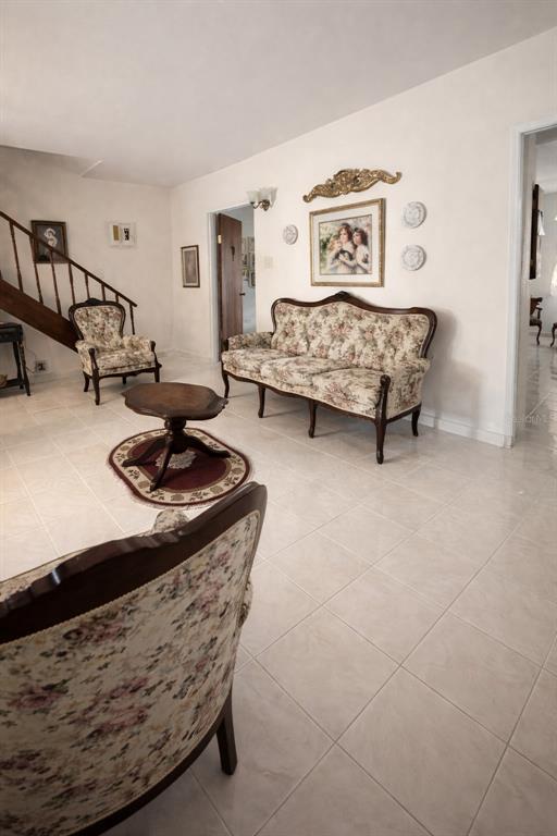 A living room features a floral sofa, matching armchairs, a small table, and tiled floors — C3120 CIPRES, TOA BAJA, PR