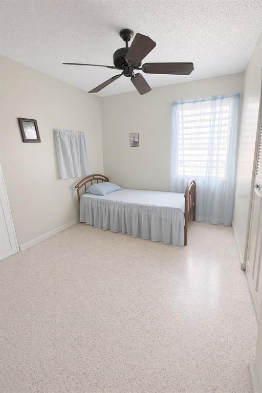 A bedroom with a single bed, a ceiling fan, and light-colored tile flooring — C3120 CIPRES, TOA BAJA, PR