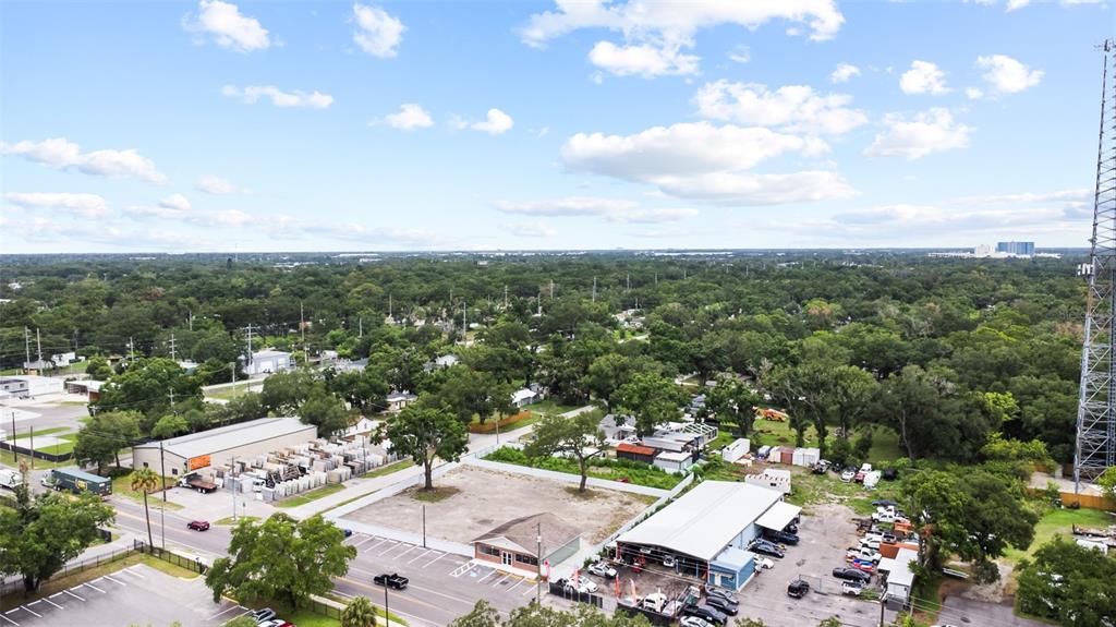 An aerial view shows a commercial lot with a small building and surrounding industrial properties — 7604 E BROADWAY AVENUE, TAMPA, FL
