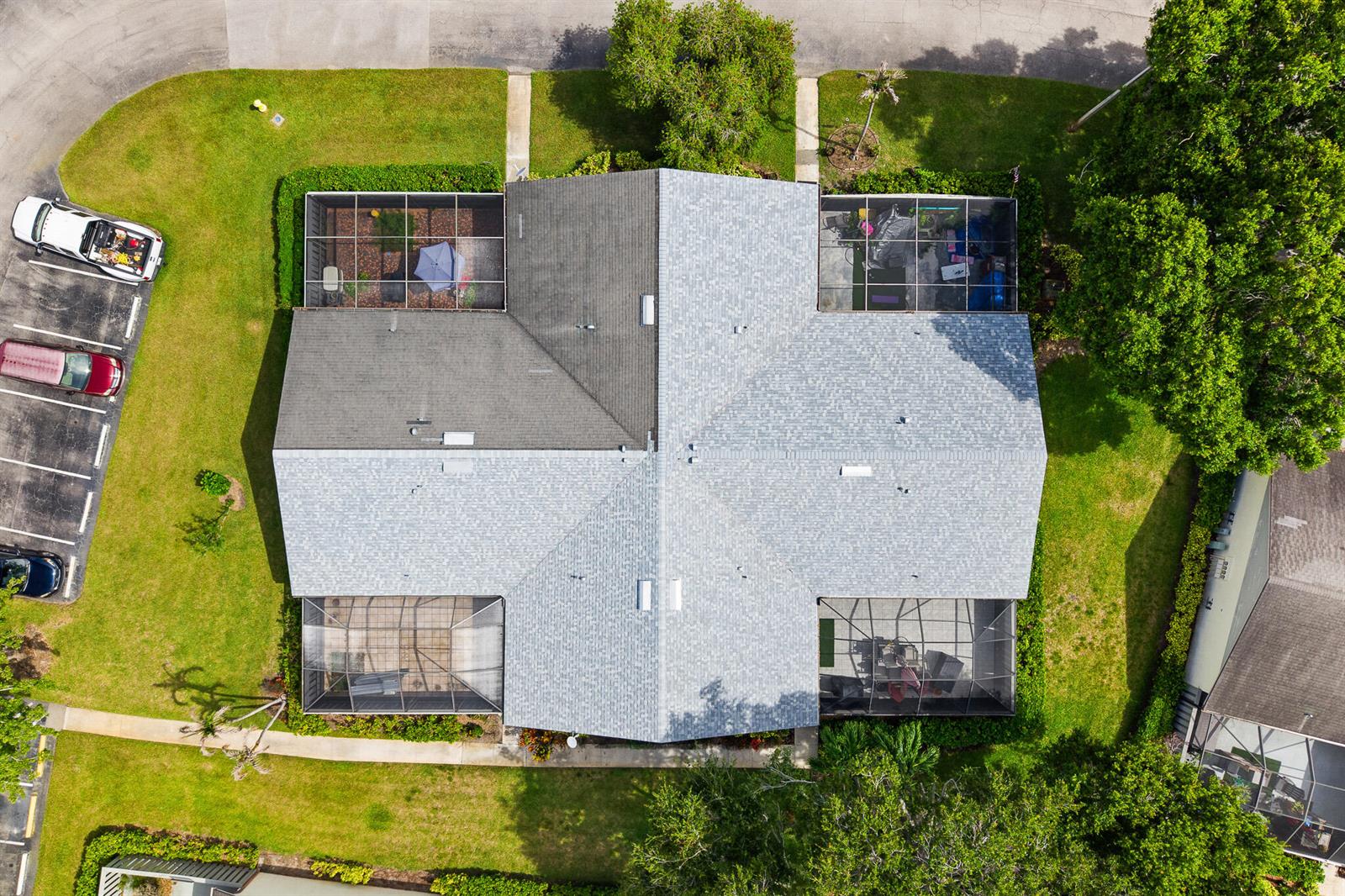 An aerial view shows a residential building with a shingled roof and four screened-in lanais — 1327 Peppertree Trail Unit A, Fort Pierce FL 34950, FORT PIERCE, FL