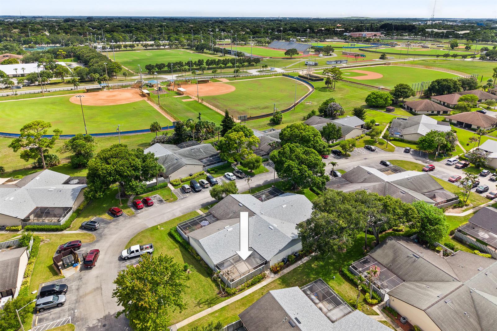 An aerial view shows a residential complex with a screened patio highlighted by an arrow — 1327 Peppertree Trail Unit A, Fort Pierce FL 34950, FORT PIERCE, FL