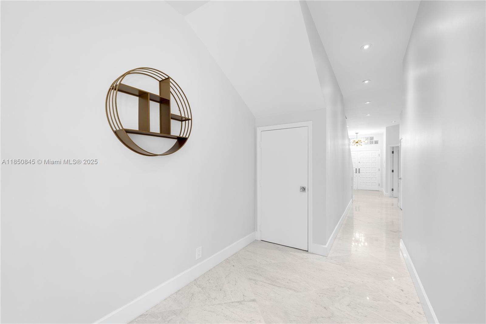 A bright hallway features white walls, marble flooring, and a circular wall-mounted shelf — 1558 NE Quayside Ter # D10, Miami FL 33138, MIAMI, FL