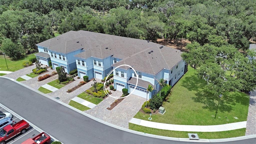 An aerial view shows a light blue multi-unit townhouse with a circled garage entrance — 4020 VIA SIENNA CIRCLE, SARASOTA, FL