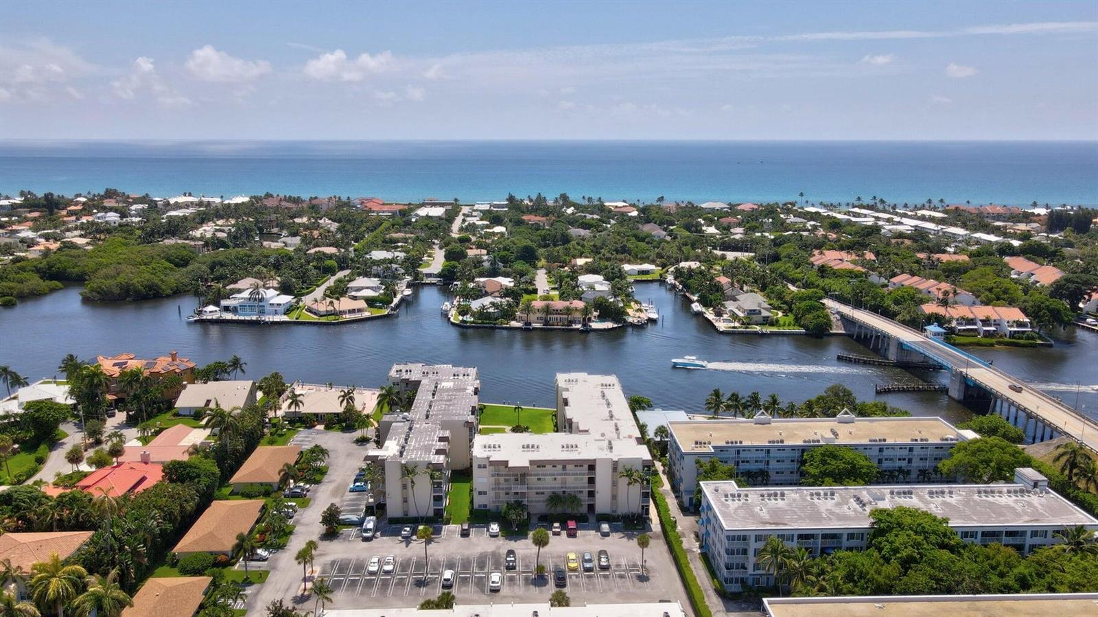 An aerial view shows a waterfront apartment complex with a parking lot near a canal — 632 Snug Harbor Drive # D3, Boynton Beach FL 33435, BOYNTON BEACH, FL