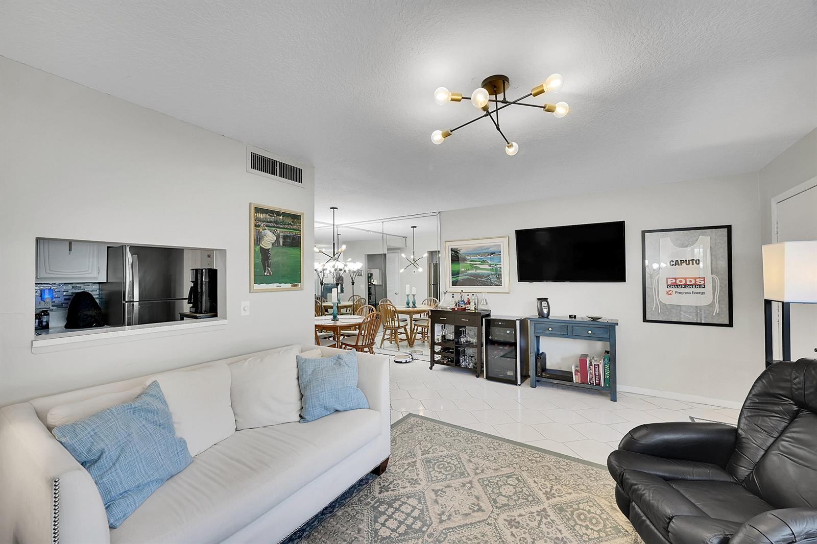 A swimming pool with lounge chairs sits in front of a building with a metal roof — 632 Snug Harbor Drive # D3, Boynton Beach FL 33435, BOYNTON BEACH, FL