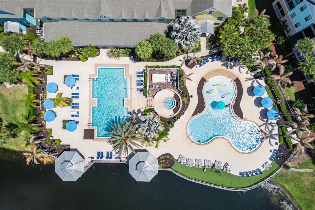 An aerial view shows a swimming pool complex with a hot tub and lounge chairs — 3019 BONFIRE BEACH DRIVE UNIT 205, KISSIMMEE, FL