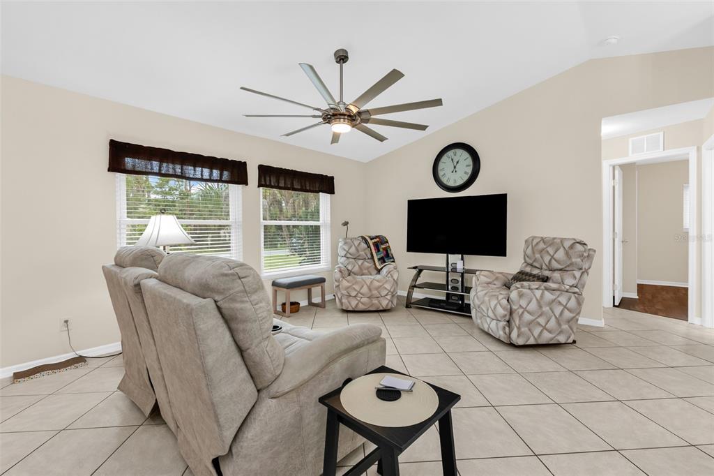 A living room with tile flooring, a ceiling fan, a television, and three recliner chairs — 3178 ALBENGA LANE, NORTH PORT, FL