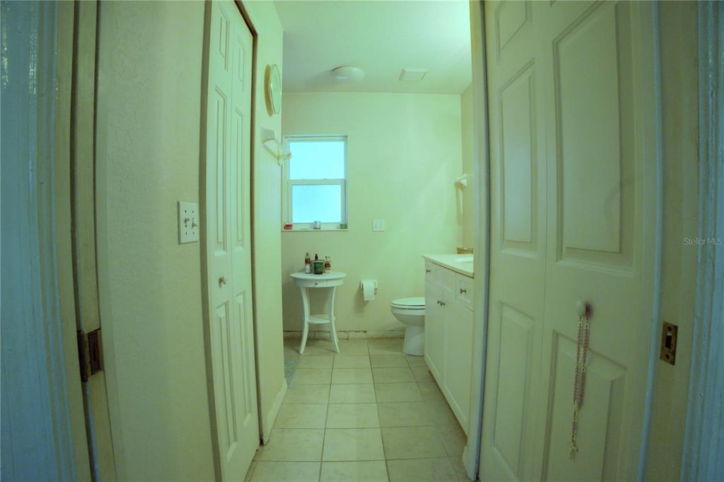 A bathroom features a white vanity, a toilet, a small round table, and tile flooring — 4621 ELDRON, NORTH PORT, FL