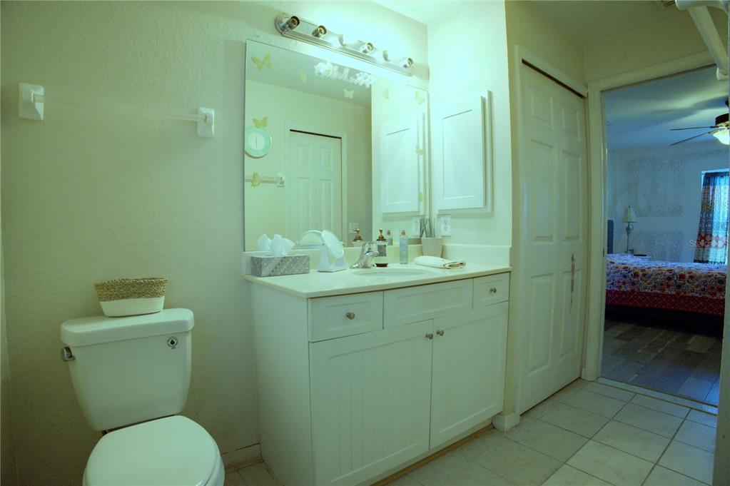 A bathroom features a white vanity, a toilet, and a mirror with overhead lighting — 4621 ELDRON, NORTH PORT, FL