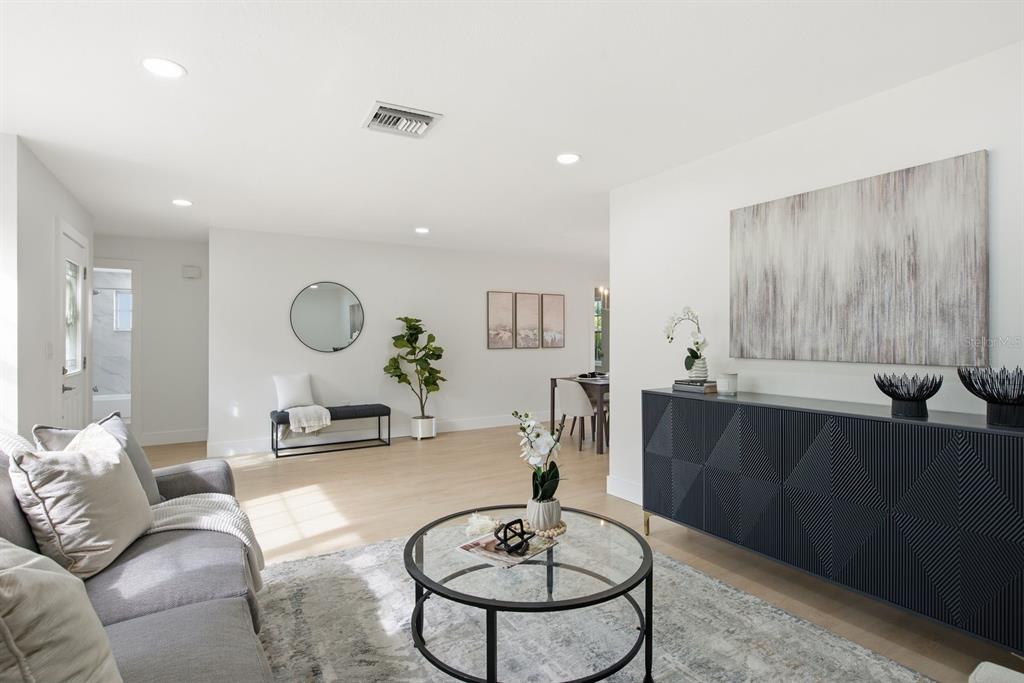 A living room features a grey sofa, a glass coffee table, and a dark sideboard — 13013 SPICEBOX WAY, HUDSON, FL