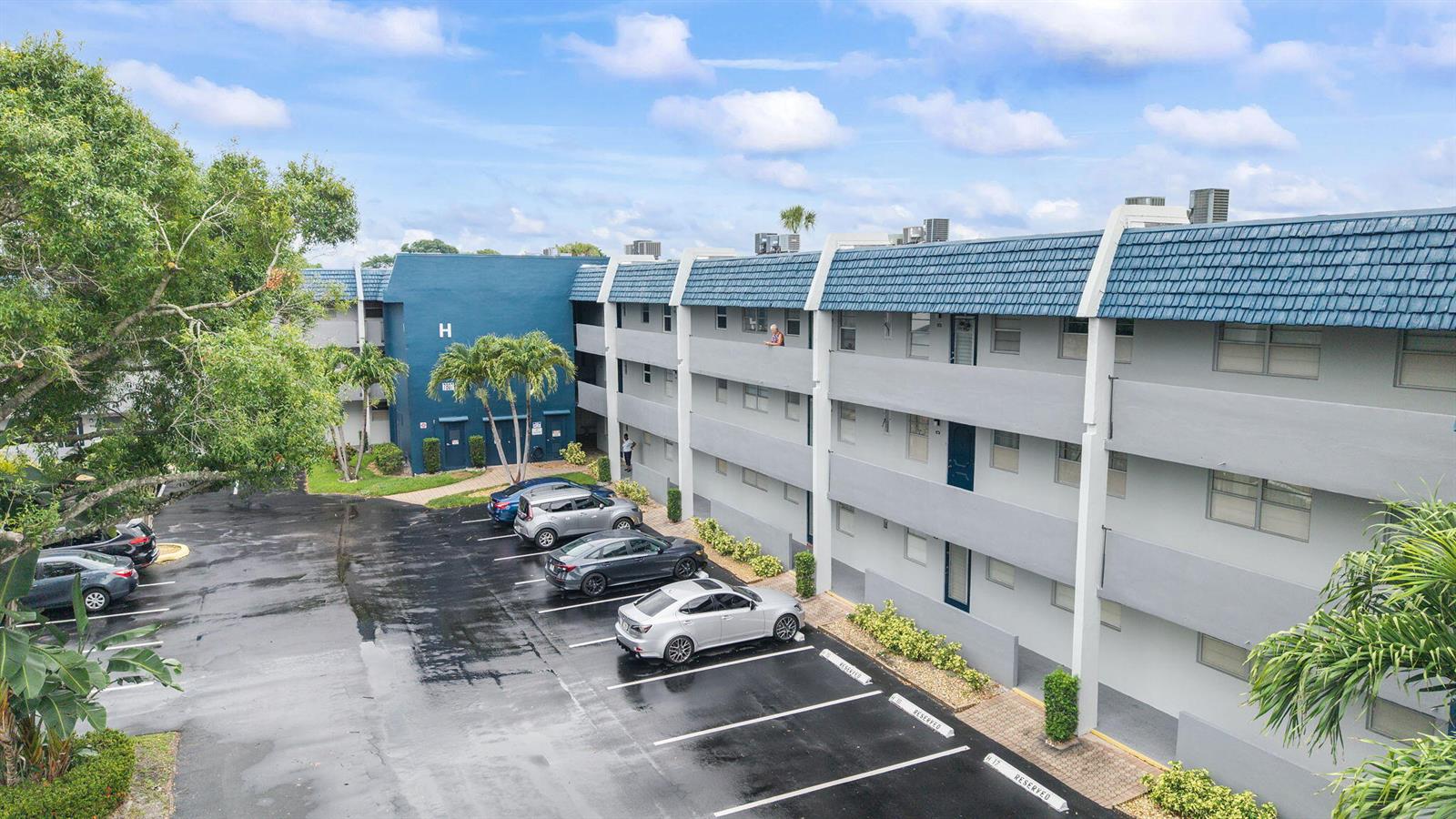 An exterior view of a multi-story apartment building with a parking lot in front — 7807 Golf Cir Drive # 305, Margate FL 33063, MARGATE, FL