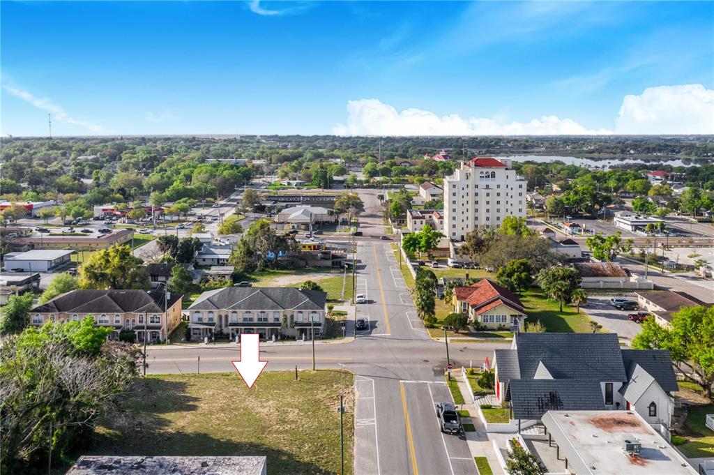 An aerial view shows a vacant lot with an arrow pointing toward it — 902 E MAIN STREET, HAINES CITY, FL