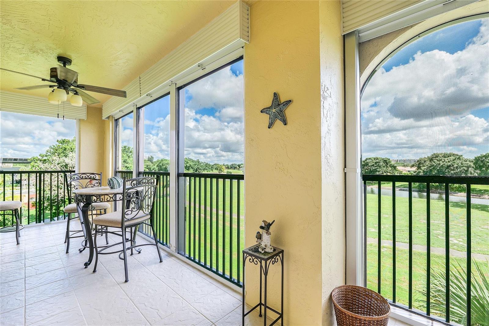 A screened-in balcony features tile flooring, a ceiling fan, and views of a grassy field — 3650 Environ Boulevard # 401, Lauderhill FL 33319, LAUDERHILL, FL