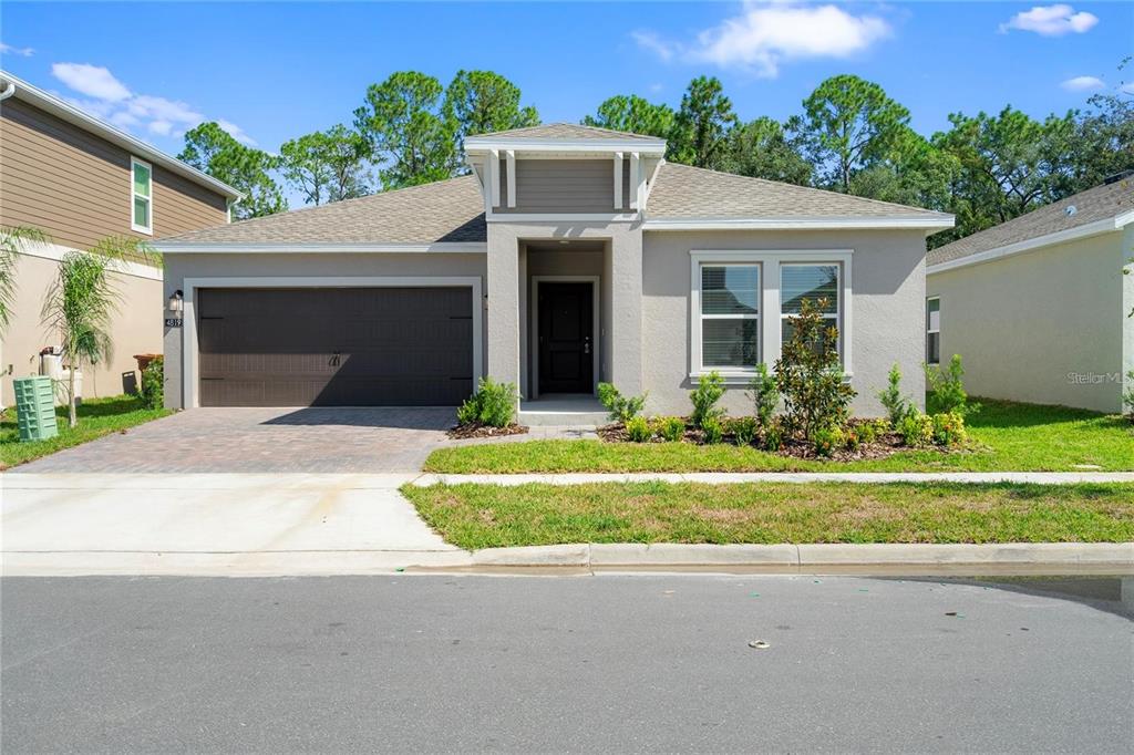 A single-story house with a gray stucco exterior, a two-car garage, and a front entrance — 4819 WORCHESTER DRIVE, KISSIMMEE, FL