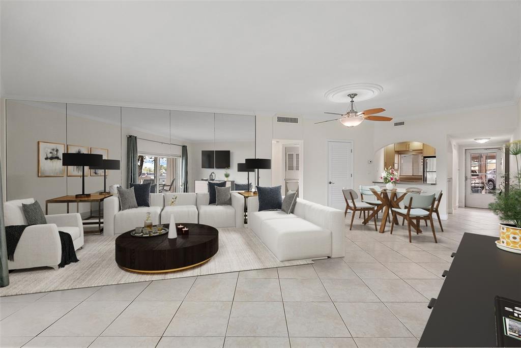 A living room with white sofas, a dark coffee table, mirrored walls, and a dining area — 1200 N SHORE DRIVE NE UNIT 102, ST PETERSBURG, FL