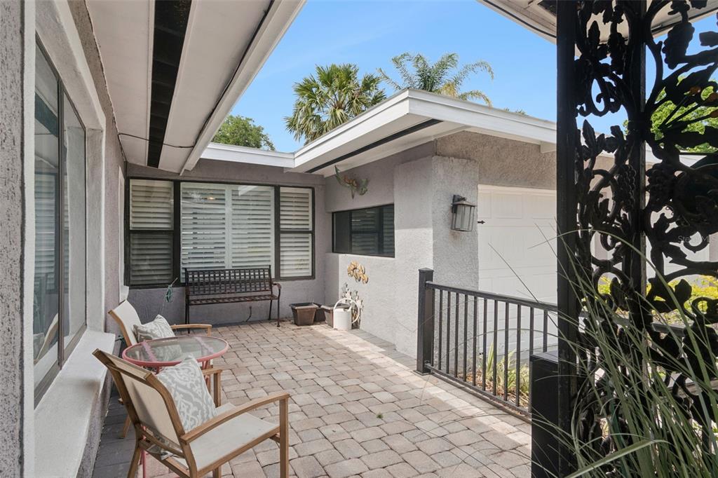 A paved patio area features outdoor seating, a metal bench, and a black railing — 140 WIGWAM PLACE, MAITLAND, FL