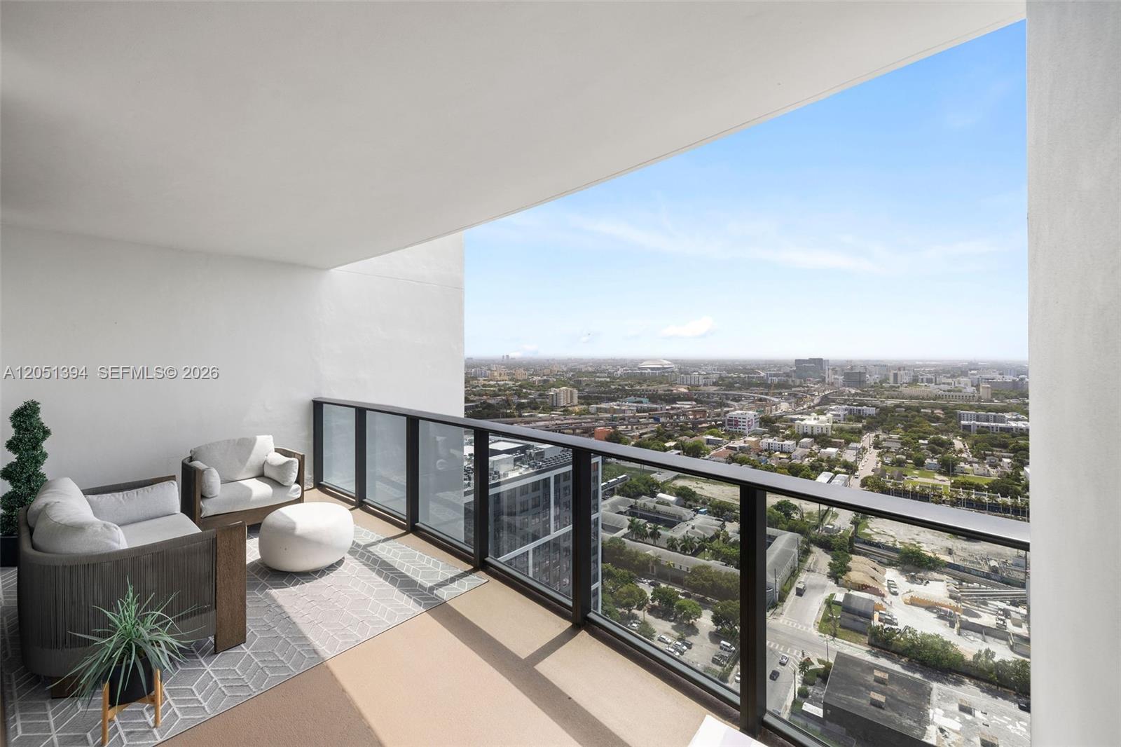 A high-rise balcony features outdoor seating, a patterned rug, and a panoramic city view — 1600 NE 1st Ave # 3111, Miami FL 33132, MIAMI, FL