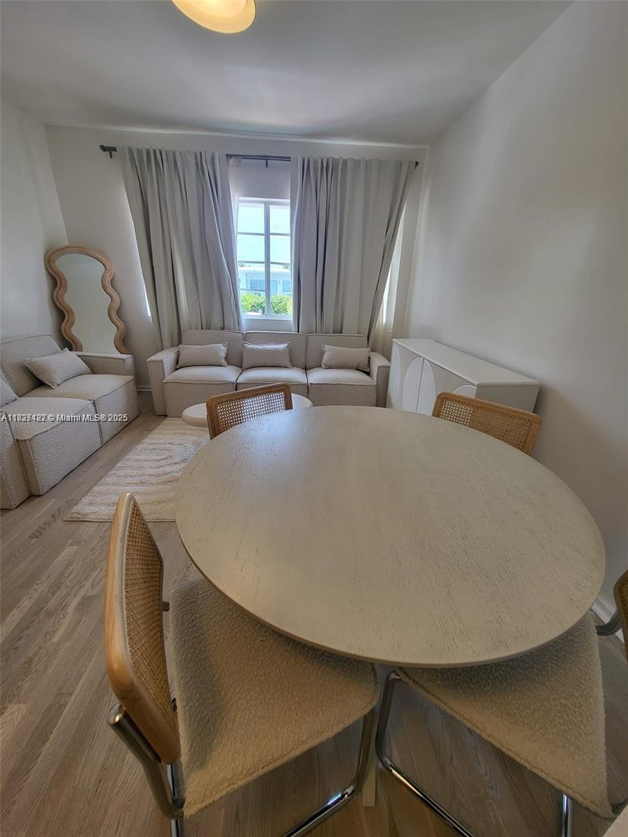 A dining area with a round table and chairs sits in front of a living room — 810 7th St # 206, Miami Beach FL 33139, MIAMI BEACH, FL