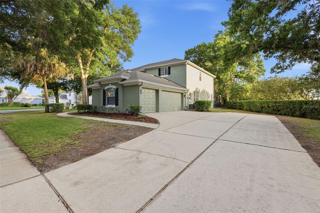 A two-story green house with a two-car garage and a concrete driveway — 1545 CHERRY RIDGE DRIVE, LAKE MARY, FL