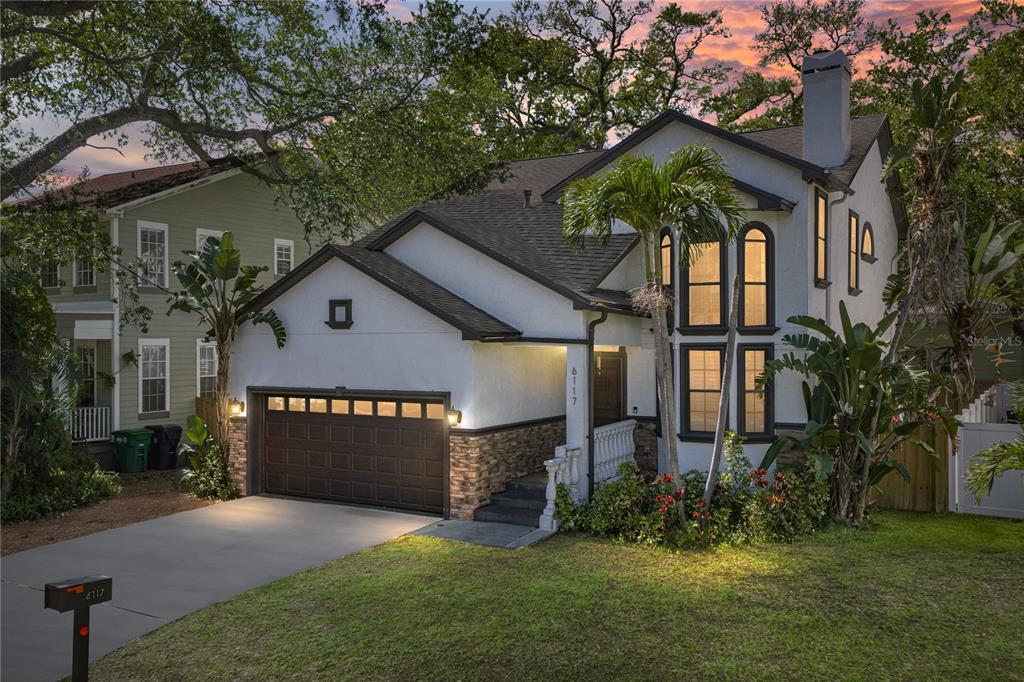 A two-story house with a white stucco exterior, stone accents, and a two-car garage — 6117 S RUSSELL STREET, TAMPA, FL