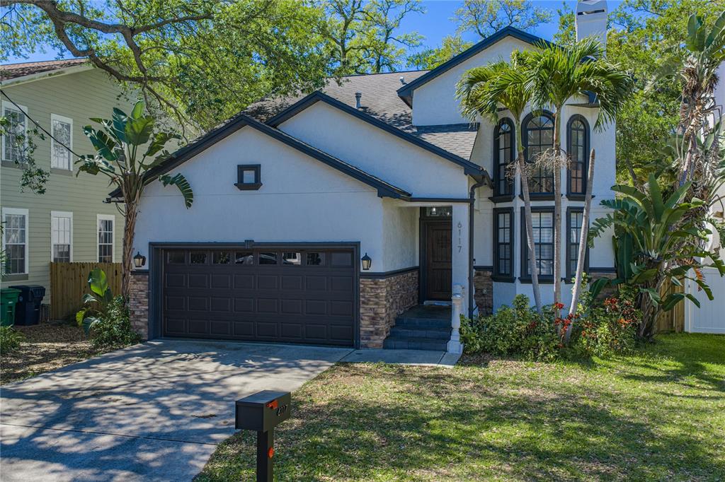 A two-story house with a white stucco exterior, dark trim, and a two-car garage — 6117 S RUSSELL STREET, TAMPA, FL