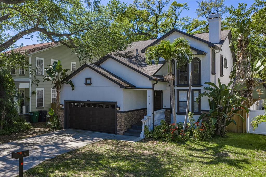 A two-story house with a white stucco exterior, stone accents, and a two-car garage — 6117 S RUSSELL STREET, TAMPA, FL