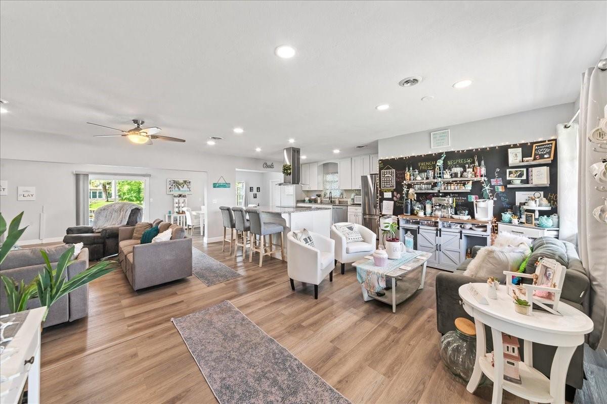 An open-concept living room and kitchen featuring light wood flooring and a chalkboard coffee station — 573 Wimbrow Drive, Sebastian FL 32958, SEBASTIAN, FL