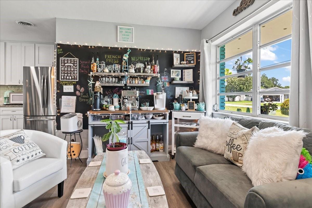 A cozy coffee-themed living room features a chalkboard wall, a coffee station, and seating — 573 Wimbrow Drive, Sebastian FL 32958, SEBASTIAN, FL