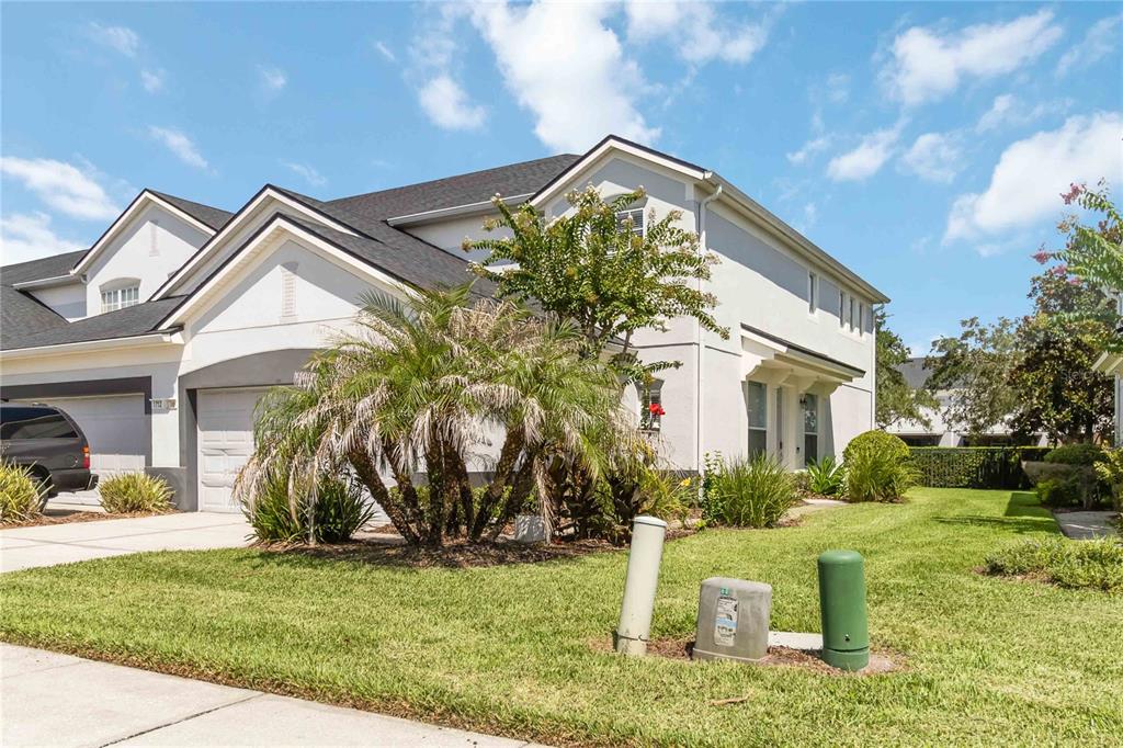 A two-story suburban house with a garage, palm tree, and lawn under a blue sky — 1706 SHALLCROSS AVENUE, ORLANDO, FL