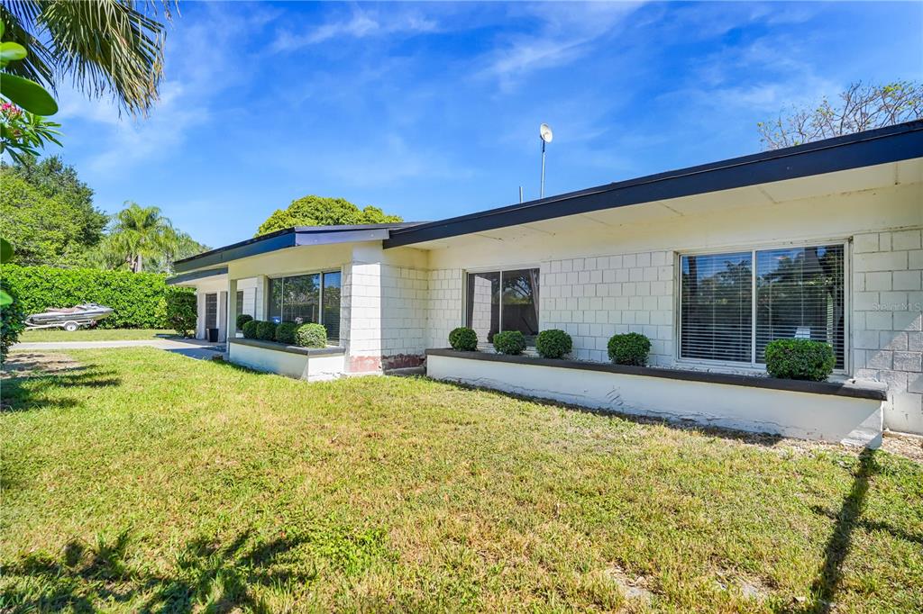 A single-story house with white block walls, dark trim, and a grassy front yard — 19755 SW 241ST TERRACE, HOMESTEAD, FL
