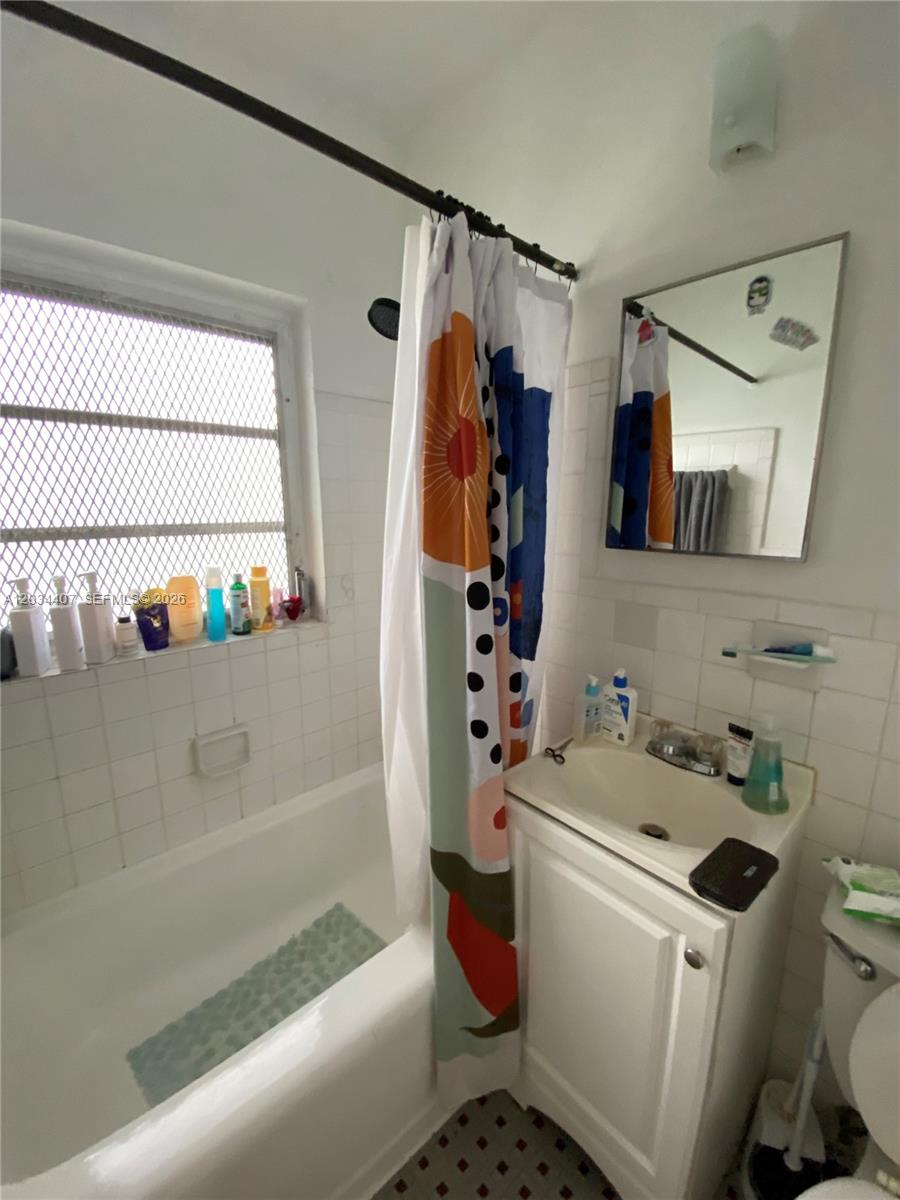 A bathroom features a white vanity, a shower-tub combination, and a window with security bars — 730 SW 10th St # 4, Miami FL 33130, MIAMI, FL