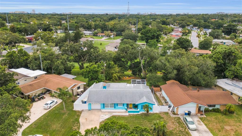 A single-story light blue house with a white garage door and a yellow front door — 1948 BYRAM DRIVE, CLEARWATER, FL