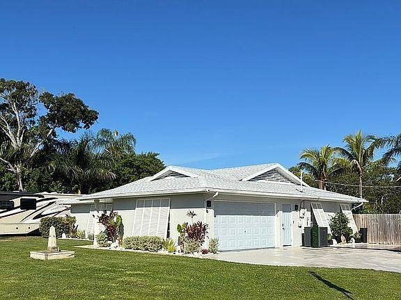 A single-story house with a white exterior, a shingled roof, and a two-car garage — 186 12th Street SE, Vero Beach FL 32962, VERO BEACH, FL
