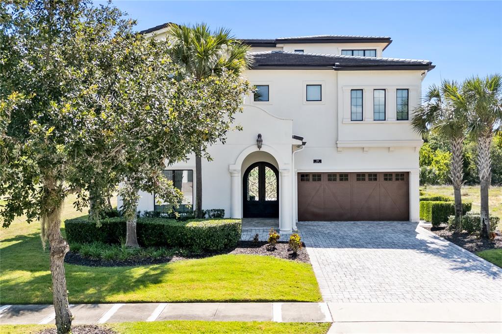 A two-story white stucco house with a brown garage door and a paved driveway — 550 MUIRFIELD LOOP, KISSIMMEE, FL