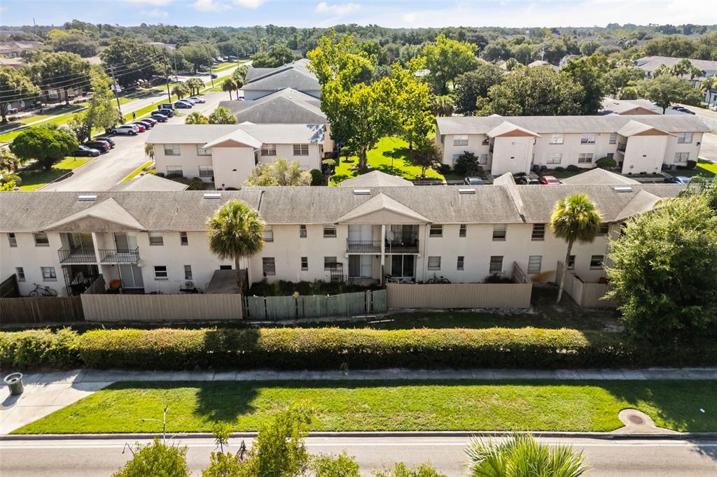 An aerial view shows a multi-story apartment complex with beige siding and a parking lot — 1910 HONOUR ROAD UNIT 4, ORLANDO, FL