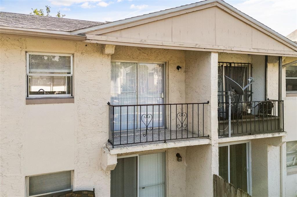 An exterior view of a two-story apartment building featuring balconies with black metal railings — 1910 HONOUR ROAD UNIT 4, ORLANDO, FL