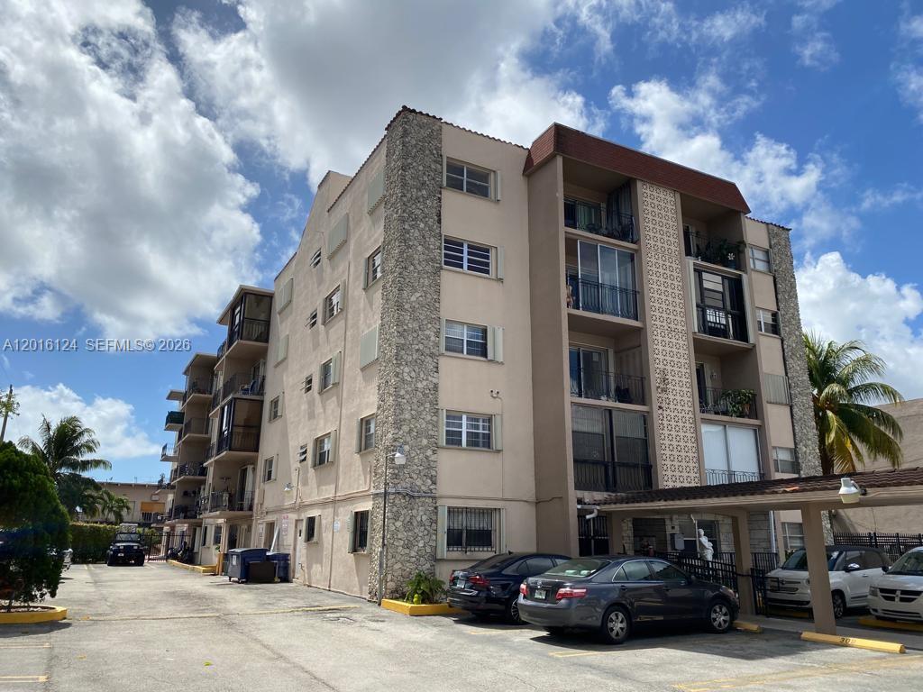A multi-story apartment building features a stone-accented facade and a covered parking area — 3640 NW 9th St # 201, Miami FL 33125, MIAMI, FL