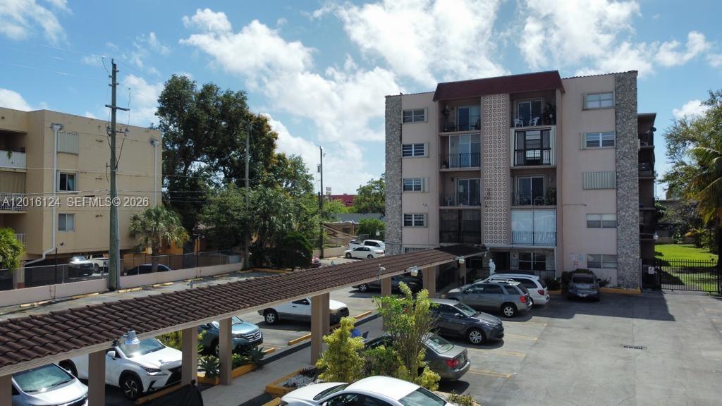 An exterior view of a multi-story apartment building with a covered parking area — 3640 NW 9th St # 201, Miami FL 33125, MIAMI, FL