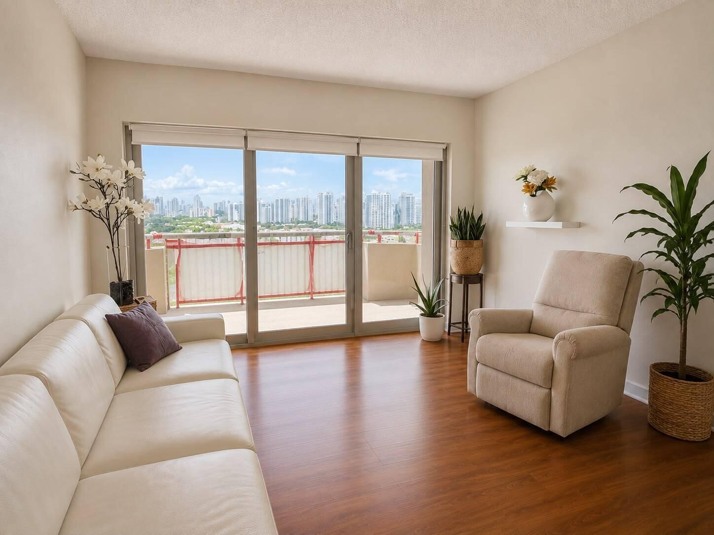 A living room with a white sofa, a recliner, wood flooring, and a balcony with city views — 1985 S Ocean Drive # 22n, FL 33009, FL