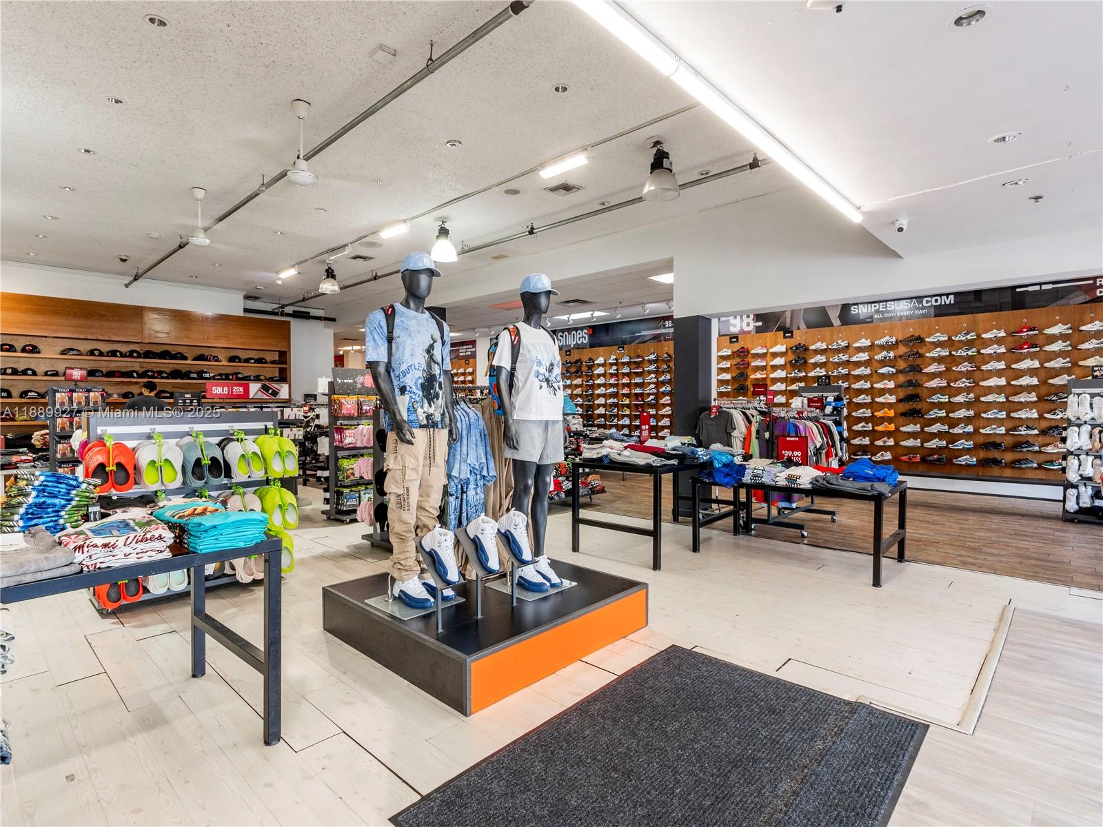 A retail store interior features mannequins, clothing displays, and shelves stocked with numerous athletic shoes — 1345 Washington Ave, Miami Beach FL 33139, MIAMI BEACH, FL